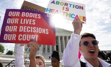 People hold pro-abortion rights placards in front of the supreme court building.