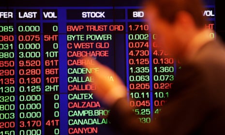 A city office worker watches the share market prices at the Australian Stock Exchange