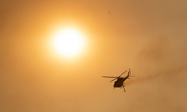 A helicopter is seen over the Orroral Valley as fire spread through the Namadgi national park in January in Canberra, Australia.