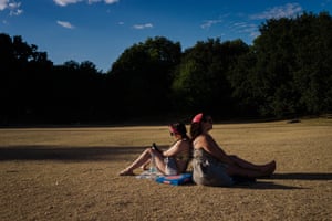 Friends sit back to back in Hyde Park