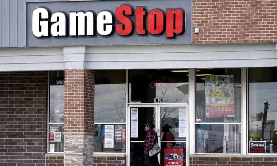 A woman wears a face mask as she walks past a GameStop store in Des Plaines, Illinois, US.