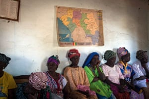 Women of Fermessadou, sitting below Guinea map