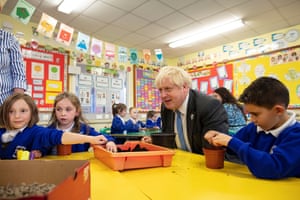 Boris Johnson joining schoolchildren planing seeds for trees during a visit to Crumlin Intergrated primary school in Northern Ireland today.