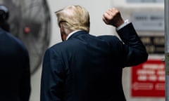 Donald Trump, with back to camera, raises a fist
