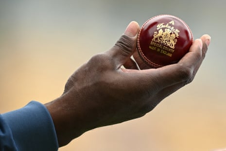 Jofra Archer inspeciona uma nova bola após selecioná-la em uma caixa.