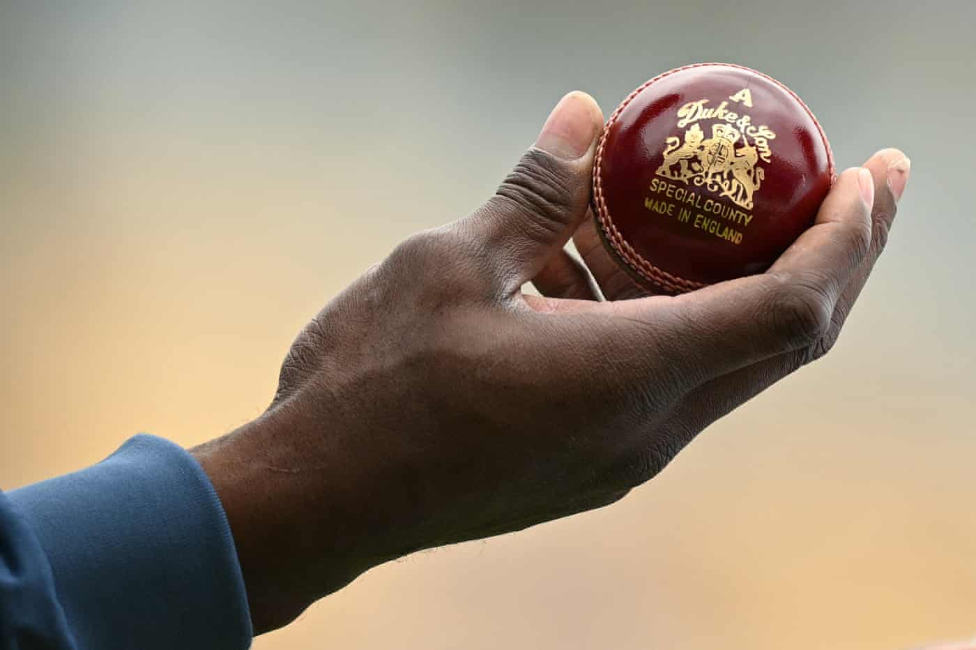 Jofra Archer inspects a new ball after selecting it from a box.