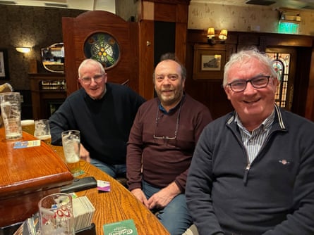 The three men sitting at a bar.