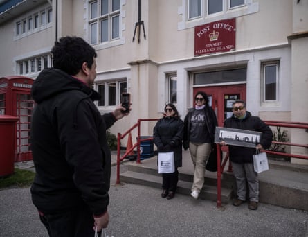 Chilean tourists pose for a photo outside the Stanley, Falkland Islands post office