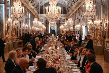 Guests successful formalwear beryllium astir a very agelong array that recedes into nan region beneath rows of chandeliers and surrounded by mirrored walls