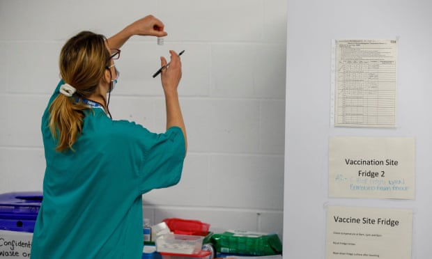 A medical woerk holds a vial of a COVID-19 vaccine as she works at a temporary vaccination centre set up in Derby