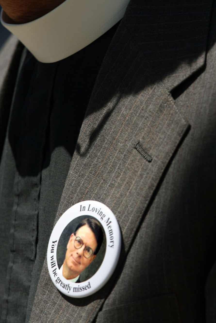 A mourner wearing a button showing George Tiller.