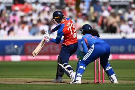 Freya Kemp of England hits the ball for six with the India wicketkeeper crouching behind the stumps