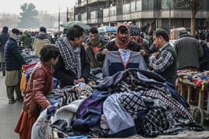 Vendors deal with customers as they sell clothes stacked on makeshift kiosks at a market area