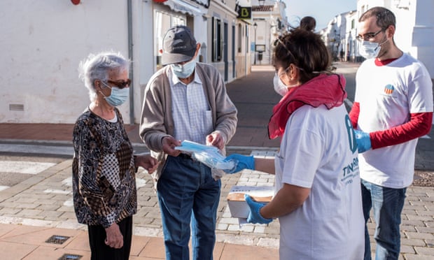 Workers inform people about the new measures and timetables following the easing of lockdown in Menorca, Spain.