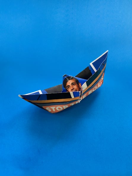 A paper boat showing Rishi Sunak’s face and the message ‘Stop the boats’ against a blue background