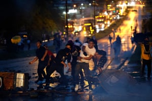 Demonstrators hurling objects on a road at night