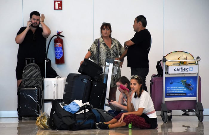 Stranded passengers waiting near the closed Thomas Cook check-in desk at the International Airport in Cancun, Mexico, today.