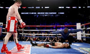 Canelo Alvarez, left, watches after knocking down Amir Khan during their WBC middleweight title fight