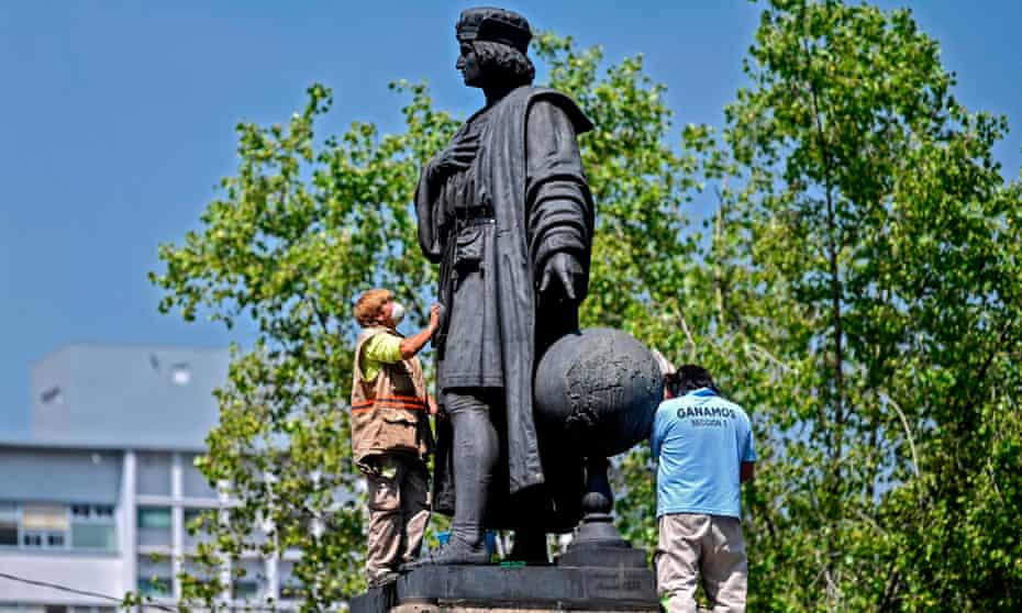 Municipal workers clean a statue of Christopher Columbus on Mexico City’s Reforma boulevard.