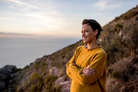 Smiling woman taking a break on a hiking trip looking at the view.