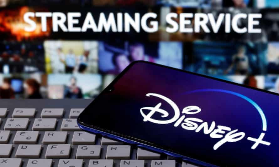 A smartphone with displayed “Disney” logo is seen on the keyboard in front of displayed “Streaming service”