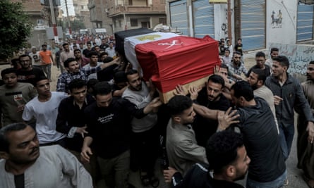 People carry and crowd around a coffin wrapped in the Egyptian national flag