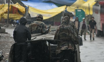 an army vehicle drives along a street