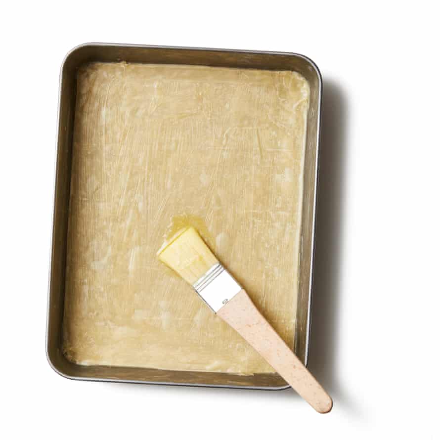 Felicity Cloake’s Baklava 05a Heat the oven to 180C (160C fan)/350F/gas 4. Liberally brush a roughly 30cm x 25cm baking tin with some of the remaining melted butter. Lay out the filo on a work surface, and have the nut mixture within easy reach. Line the tin with a sheet of filo, brush with melted butter and repeat with five more sheets, buttering them as you go.