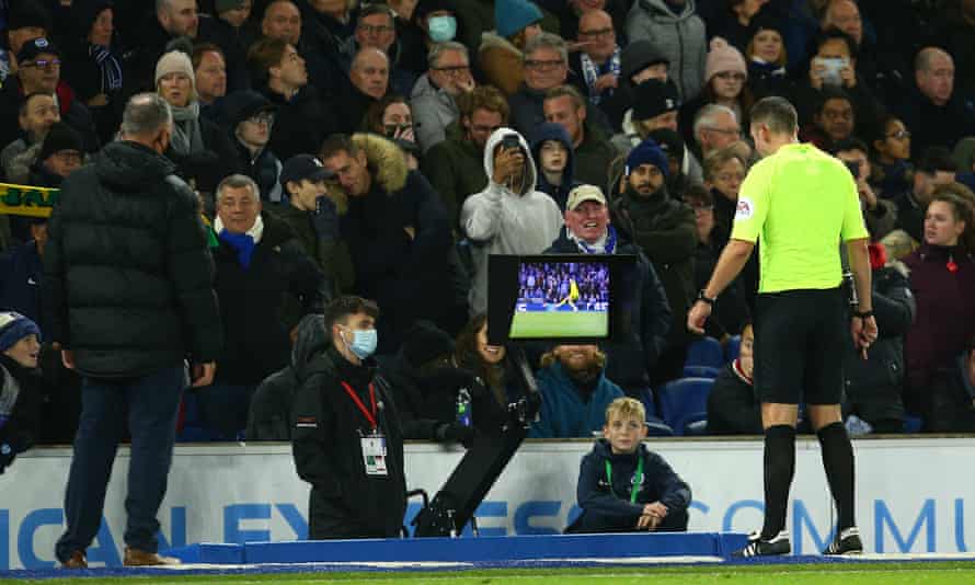 Referee David Coote checks the VAR screen before giving a red card to Robert Sanchez of Brighton &amp; Hove Albion.