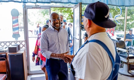 Democratic Senator from Georgia Raphael Warnock meets barber shop owner Stan Seldon during a reelection campaign stop in Newnan, Georgia.