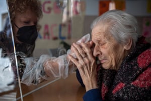 A resident of the Villa Sacra Famiglia nursing home, Anna, hugs her daughter through a plastic screen in during the Covid-19 pandemic in Rome.