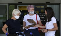 A Algarve tourism authority worker hands out COVID-19 welcome kits containing masks and disinfectant to passengers from the United Kingdom arriving at Faro airport, outside Faro, in Portugal’s southern Algarve region, Monday, May 17, 2021. British vacationers began arriving in large numbers in southern Portugal on Monday for the first time in more than a year, after governments in the two countries eased their COVID-19 pandemic travel restrictions. (AP Photo/Ana Brigida)