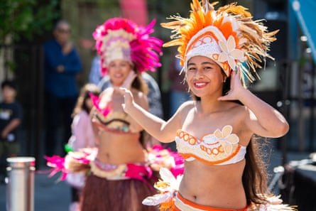 Traditional Cook Island dancers wearing colourful headdresses perform in the street