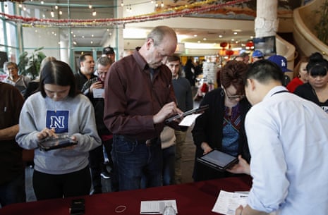 Voters sign in on tablet computers at an early voting location in the Chinatown Plaza, in Las Vegas.