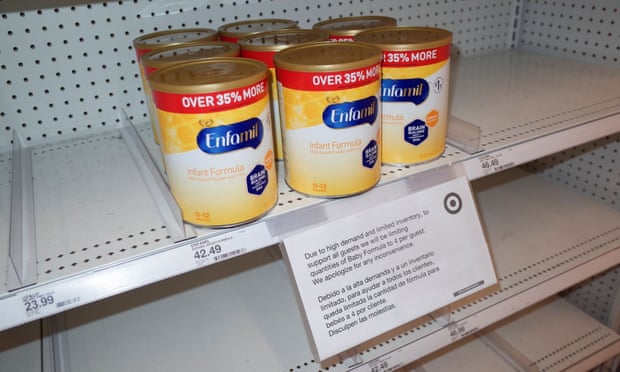 Cans of Enfamil baby formula, produced by Mead Johnson, on partially empty shelves in a Target store.