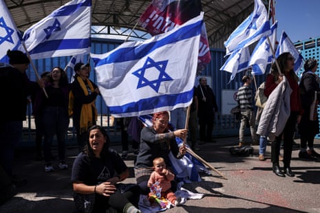 Israelis hold flags as they protest outside Unrwa offices in Jerusalem for the return of hostages held in Gaza since 7 October.