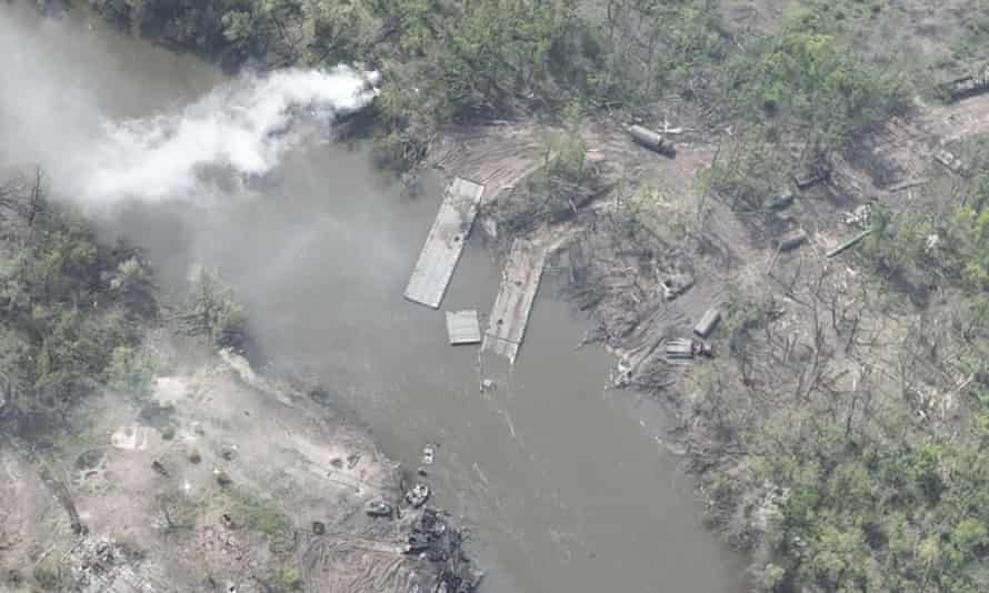 An aerial photograph  of a ruined pontoon crossing with dozens of destroyed Russian armoured vehicles connected  the banks of Siverskyi Donets River,