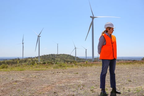 Annastacia Palaszczuk stands in front of wind turbines.