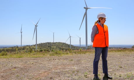 Annastacia Palaszczuk stands in front of wind turbines.