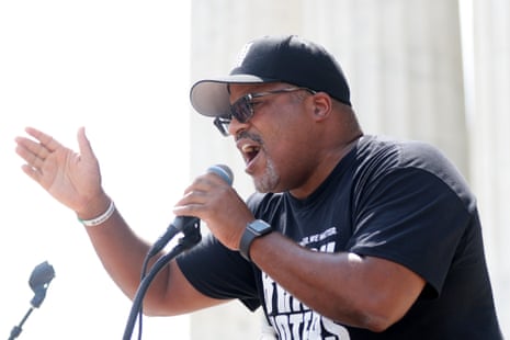 man gestures while speaking at mic