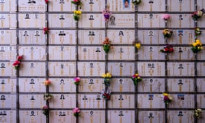 Flowers are placed next to photos of deceased loved ones at a Hong Kong columbarium during the Qingming festival.