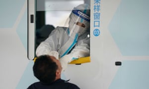 Medical worker collects a swab from a man for nucleic acid testing in Beijing