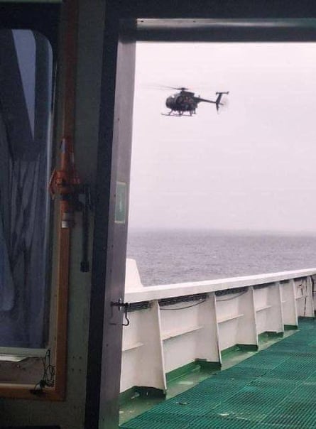 A shot taken from the deck of a vessel shows a helicopter approaching