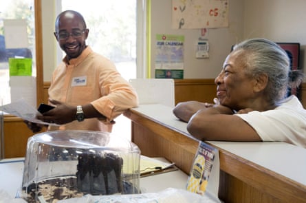 Man leans on counter smiling, as older woman with chin on her crossed arms smiles back.