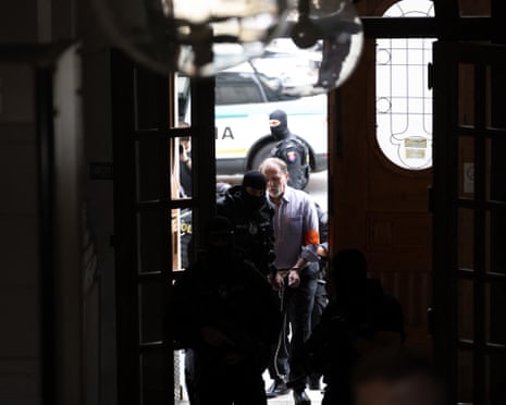 Police escort Juraj Cintula (R), a 72-year-old man on trial for last year’s attempted assassination of Slovakia’s prime minister Robert Fico, into the courtroom in Banská Bystrica, Slovakia.