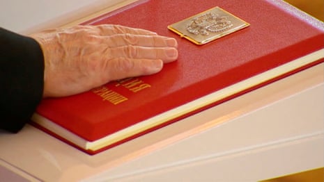 Russian President Vladimir Putin places his hand on the Constitution as he takes the oath during an inauguration ceremony at the Kremlin in Moscow, Russia.