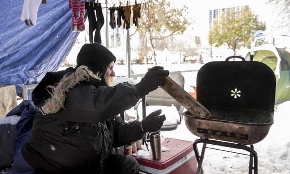 Tim tends a fire he used for heat and cooking at a homeless camp in Austin, Texas, during an extreme cold snap in February.