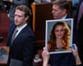 An image of a young girl is held up as Mark Zuckerberg walks past