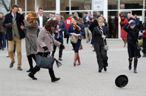 A racegoer chases her hat before the racing
