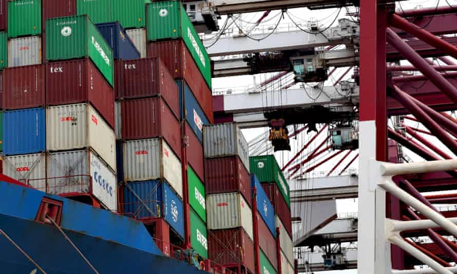 Cranes serve a container ship at a dockyard in Qingdao in Shandong province